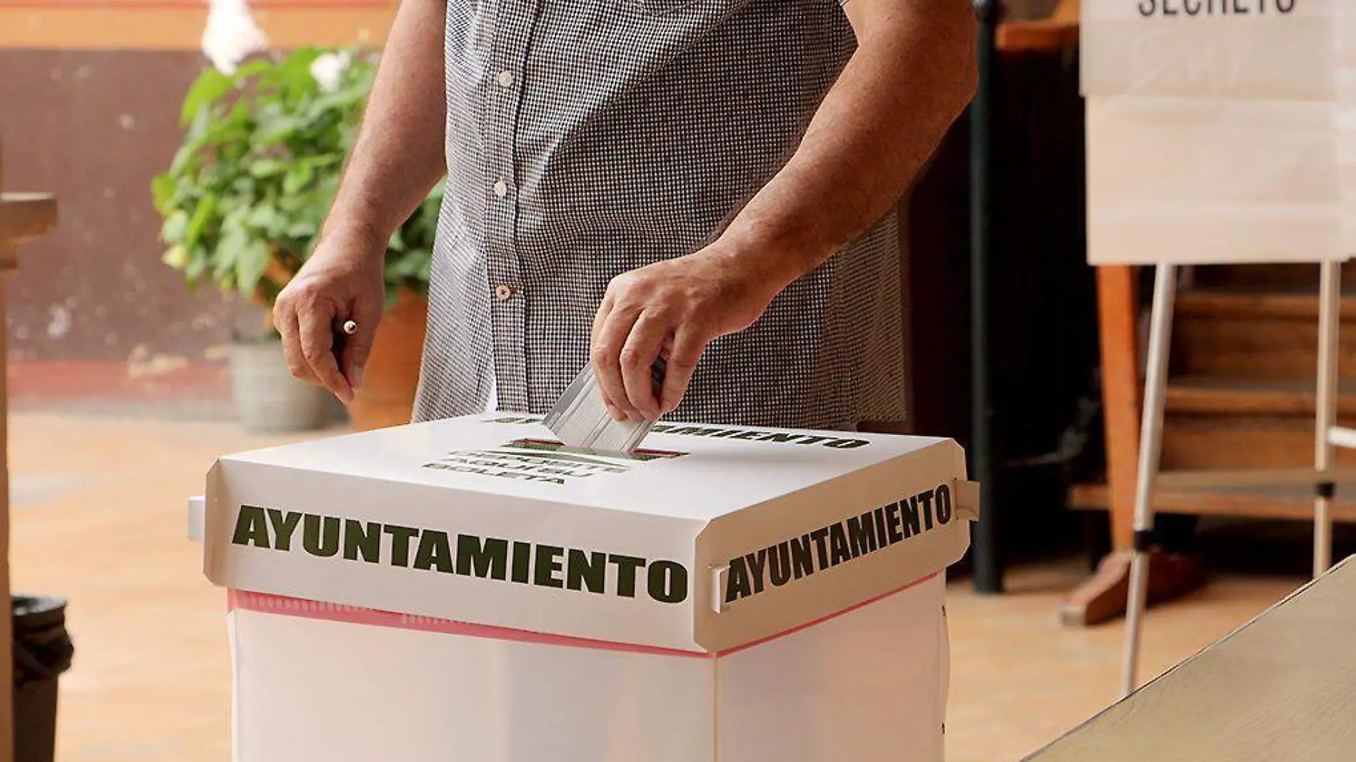 Persona introduciendo su voto a una urna